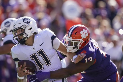 Connecticut quarterback Jack Zergiotis (11) is sacked by Clemson defensive tackle Tyler Davis (13) in the first half of an NCAA college football game, Saturday, Nov. 13, 2021, in Clemson, S.C. (AP Photo/Brynn Anderson, file)
