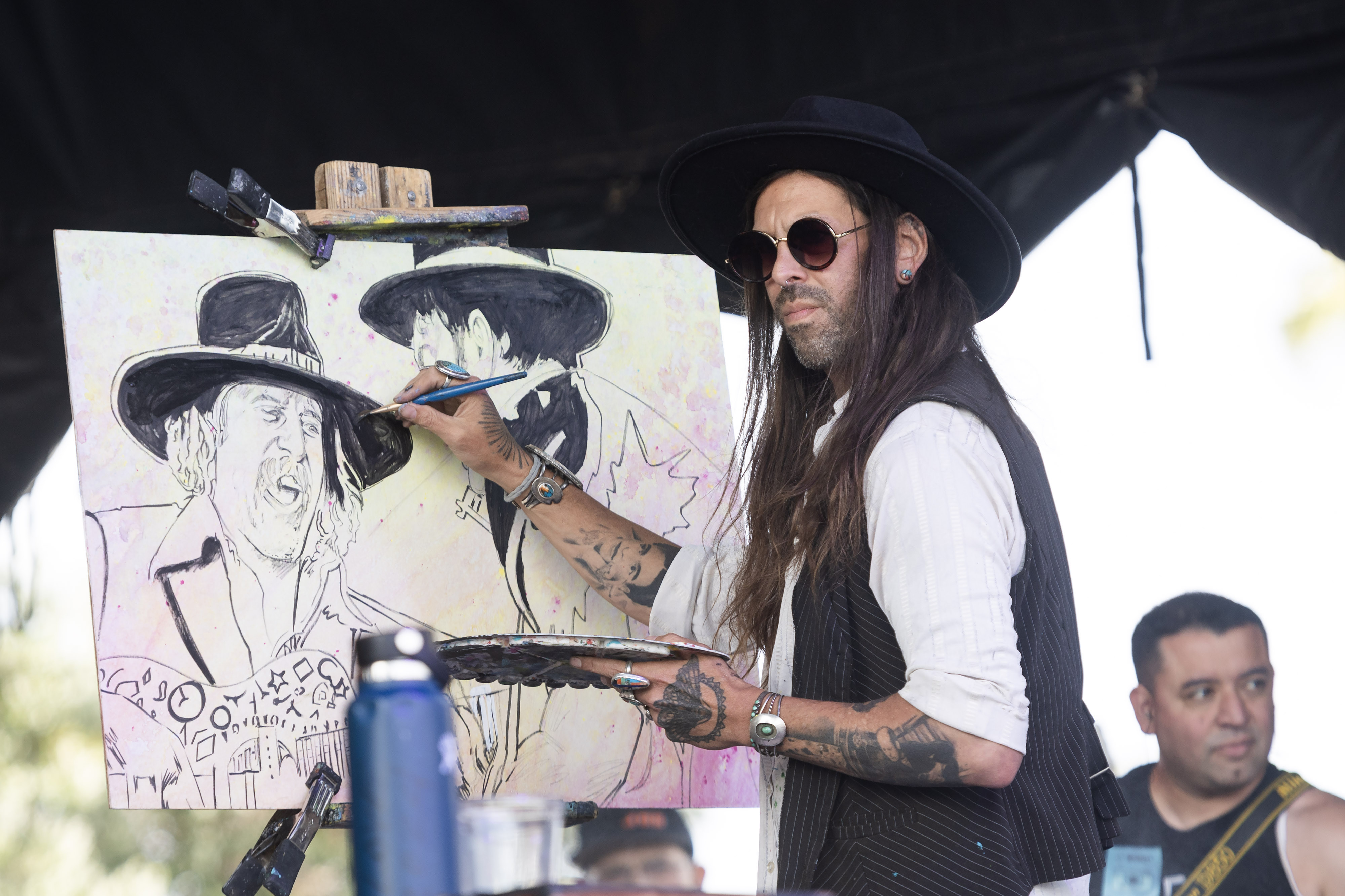 An artist live paints during a performance by G. Love...
